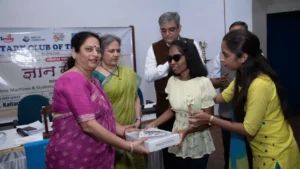 Volunteers presenting support material to a young visually impaired participant.